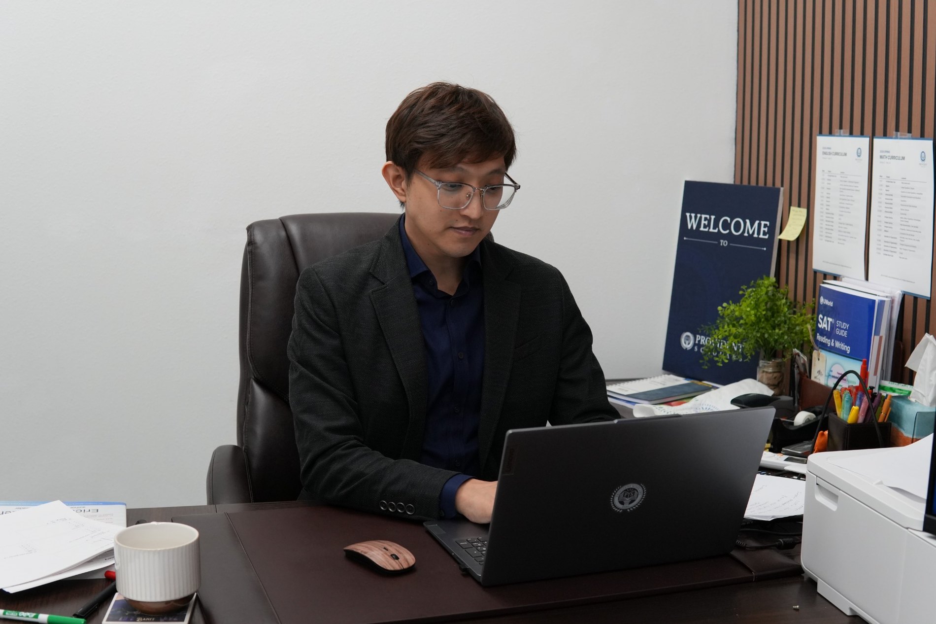 Dr. Jiwon Seo working at his desk in the Provident Scholars classroom